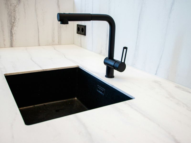 Black Undermount sink with black faucet in cream color kitchen