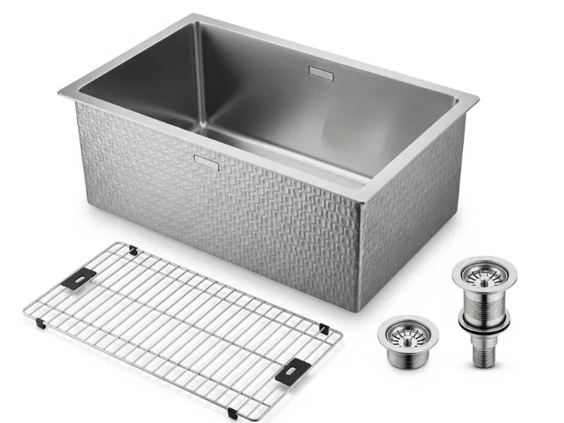 A studio shot of a 33-inch stainless steel sink with a unique 3D embossed texture, shown with a bottom grid and drain parts