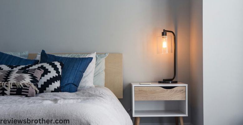 a bed in the bedroom along with a lamp on a side table